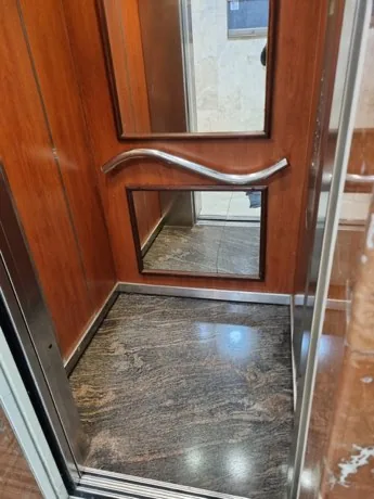 תא מעלית מחופה עץ עם רצפת גרניט מבריקה אחרי ניקוי