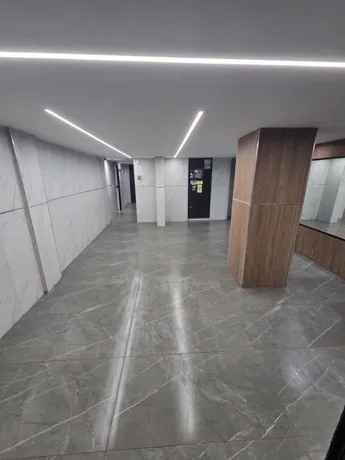 לובי משופץ עם חיפוי שיש ותאורת LED לינארית